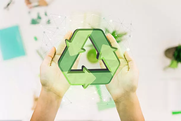Mãos segurando símbolo de reciclagem